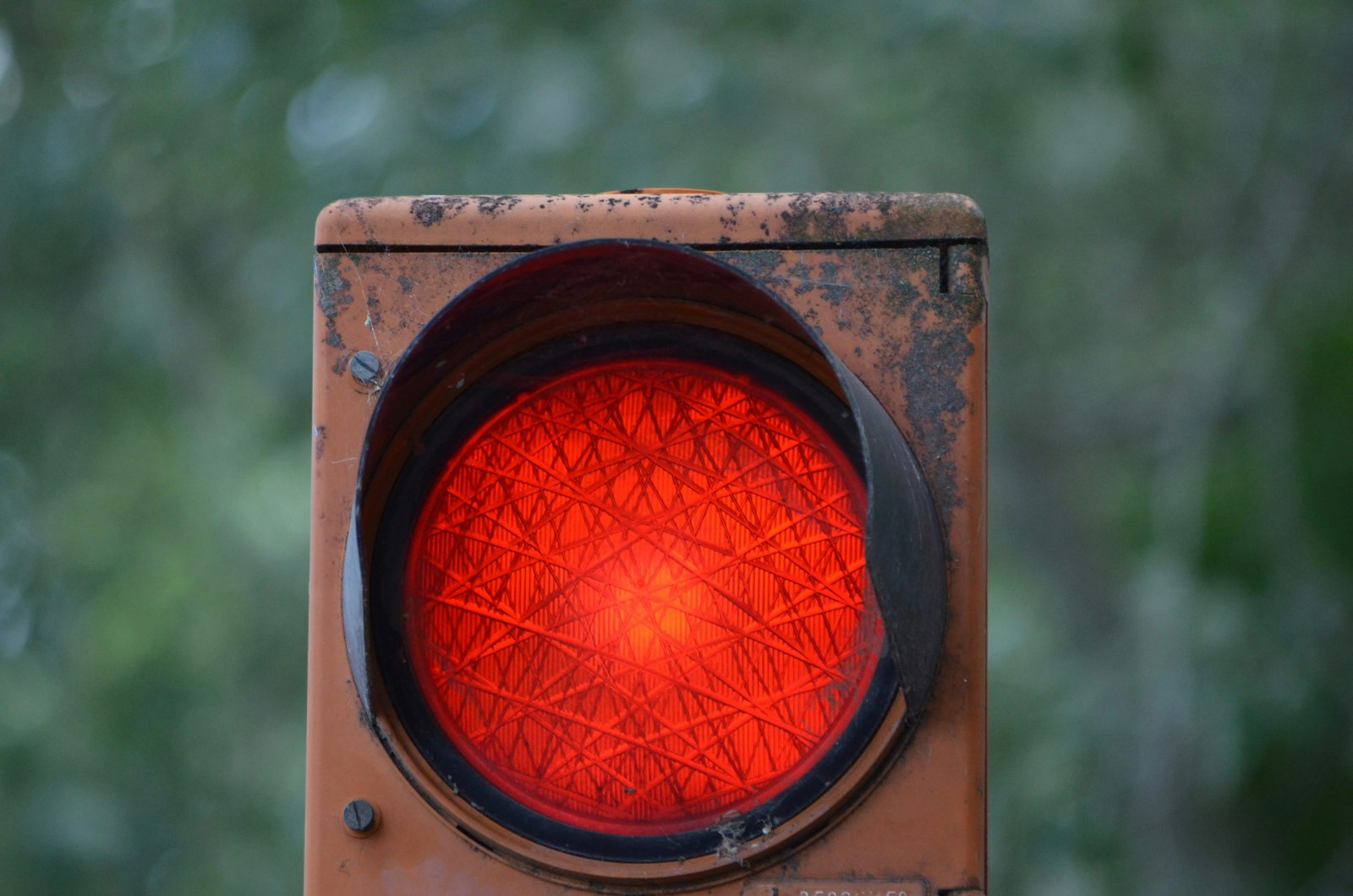 Weathered railway signal lamp showing red