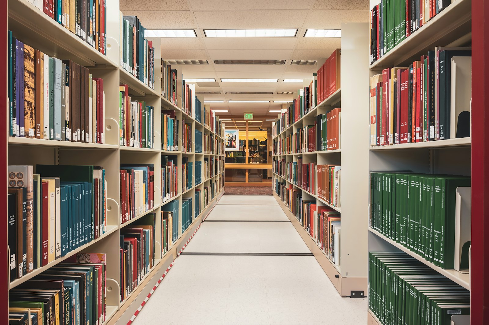 Library aisle between tall shelves of catalogued books