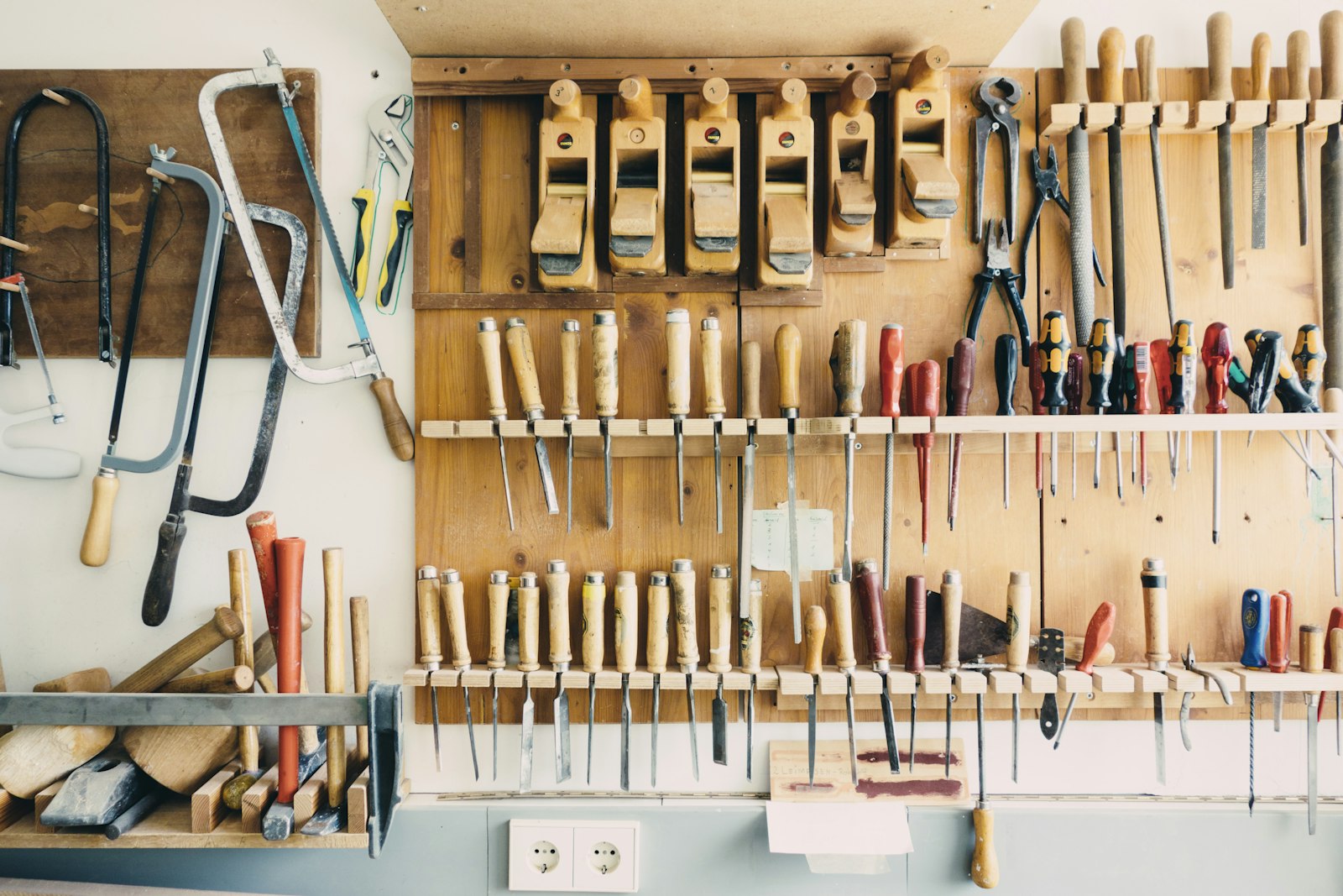 Workshop wall with saws, chisels and screwdrivers in racks
