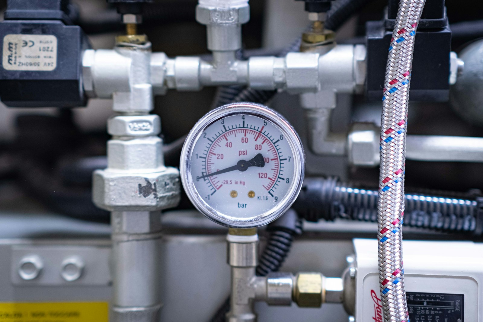 Pressure gauge mounted among pipes and valves