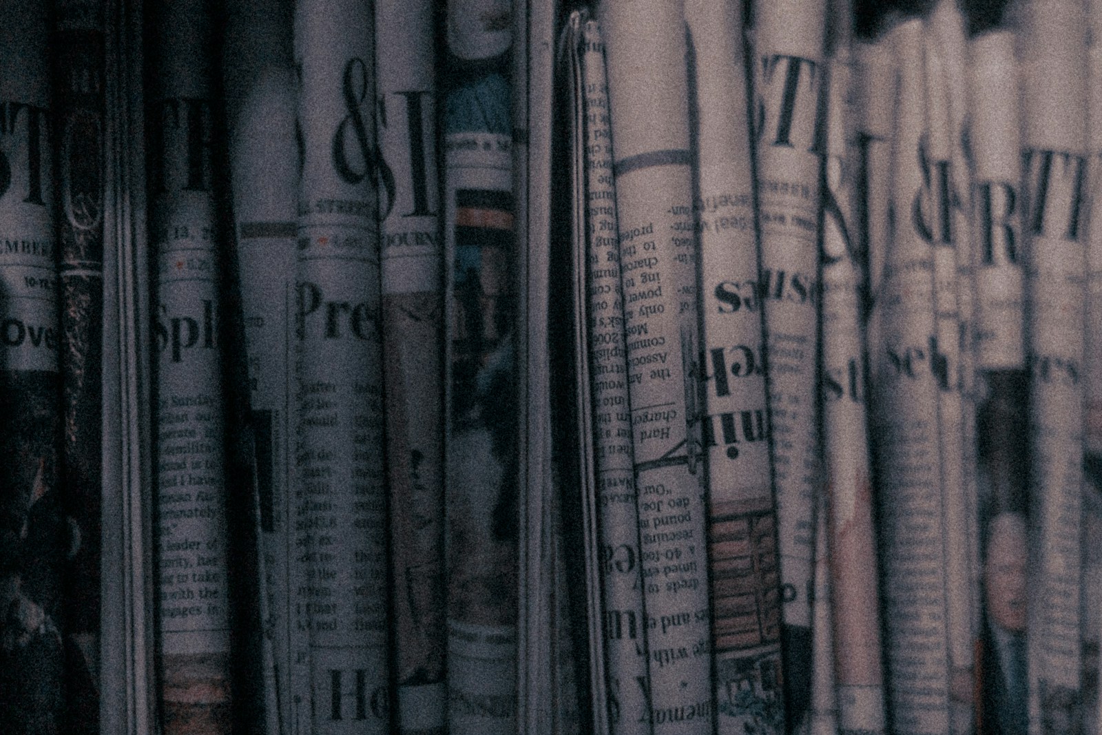 A row of folded newspapers standing on a shelf